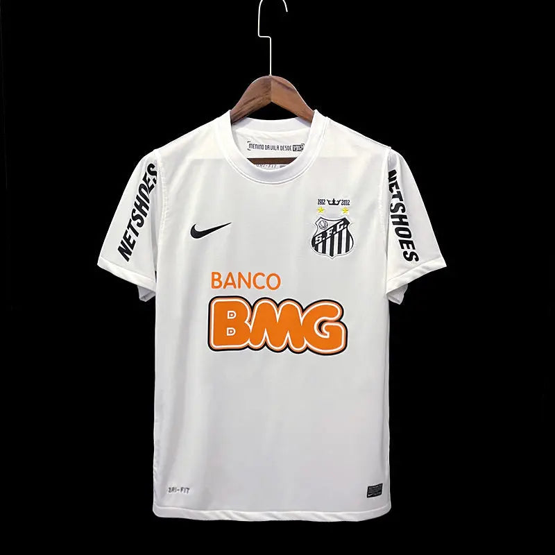 Design classique blanc avec détails noirs, logo vintage du club, hommage aux légendes comme Neymar, tissu léger et confortable.